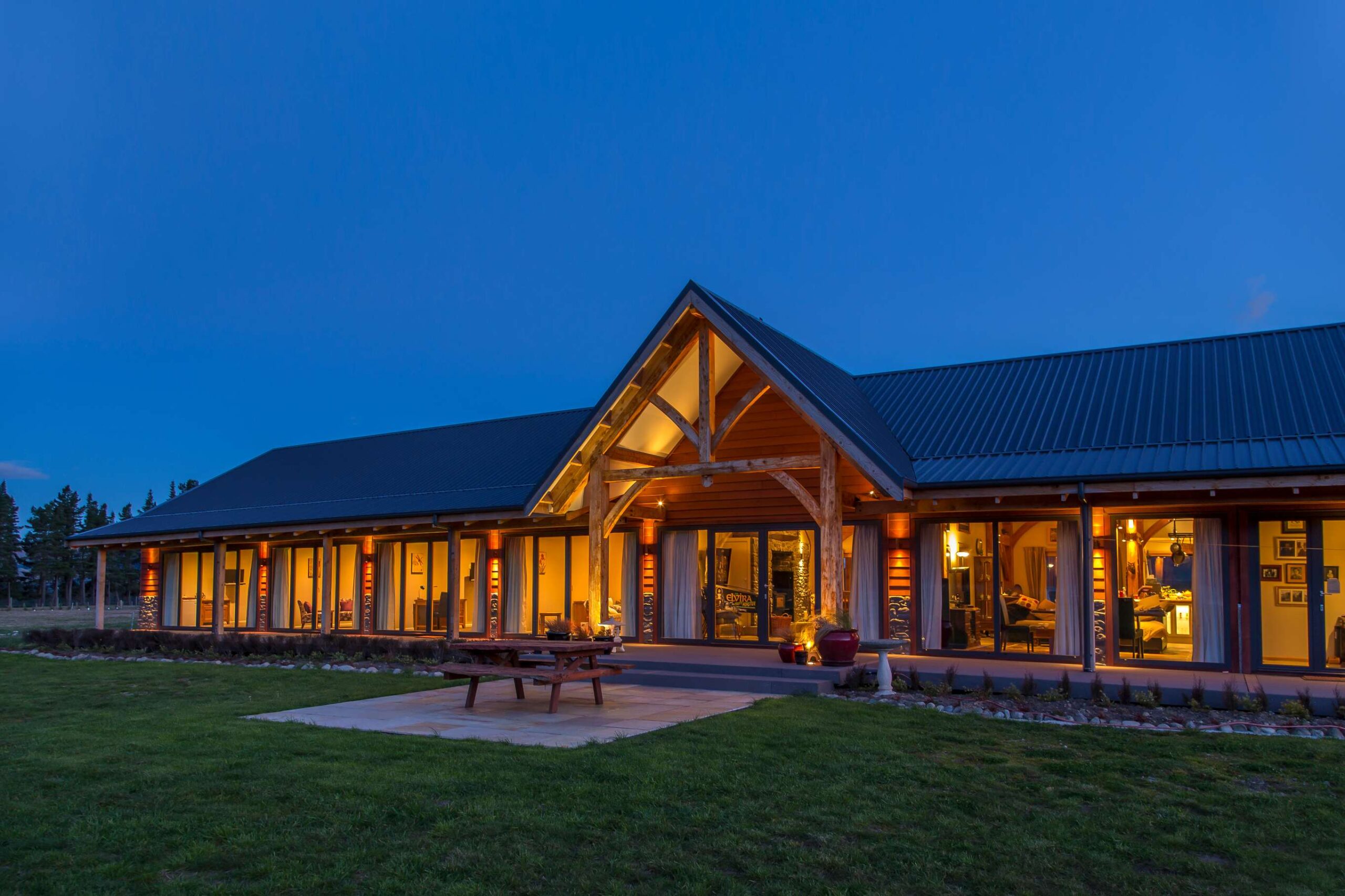 Stylish New Zealand barn home with timber trusses, luxury bedroom, and vaulted ceiling